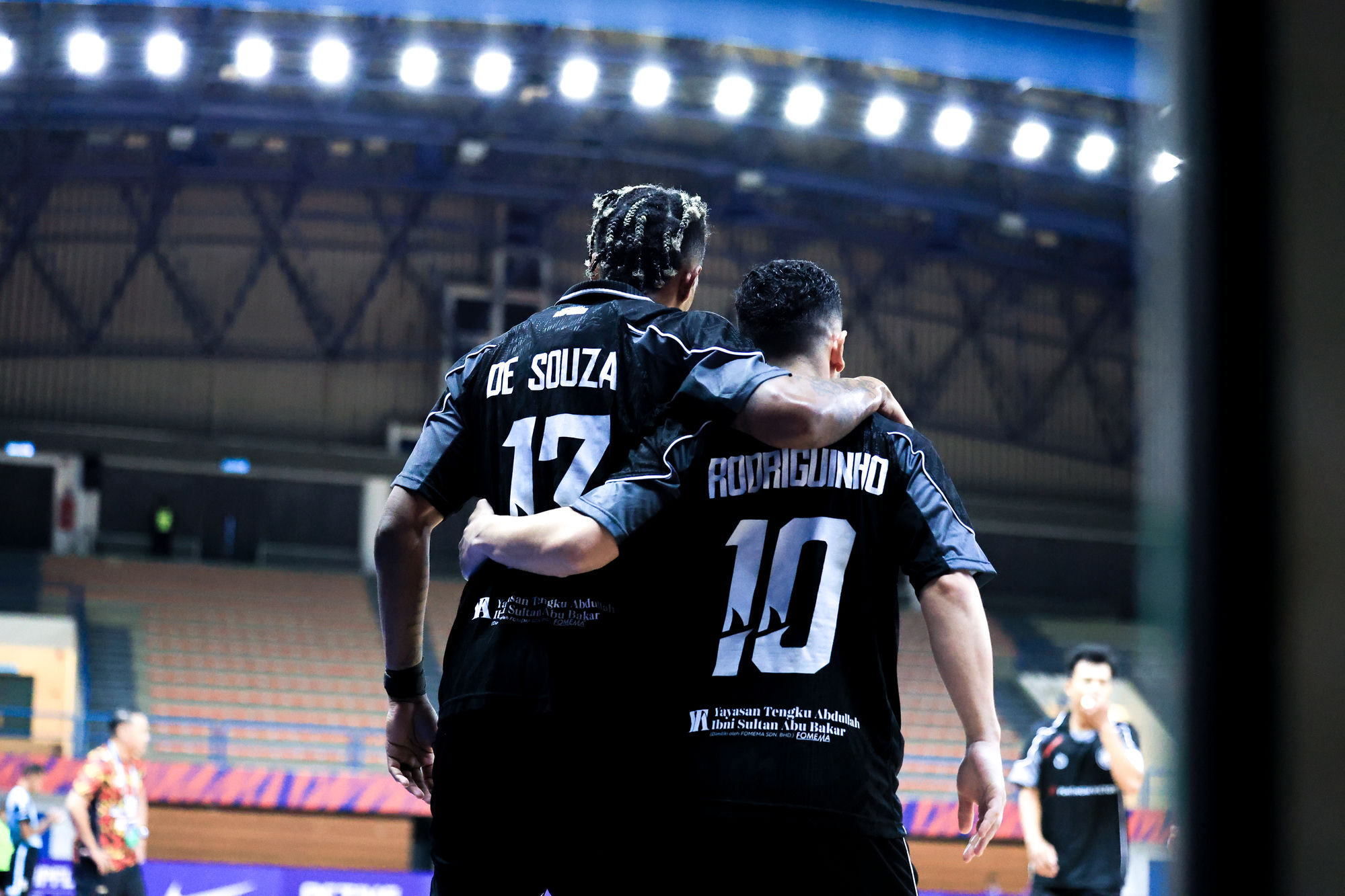 Teammates walk arm-in-arm after a goal