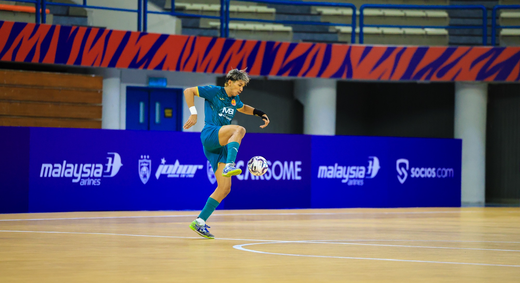 MPFL player on a futsal court with sponsor boards behind